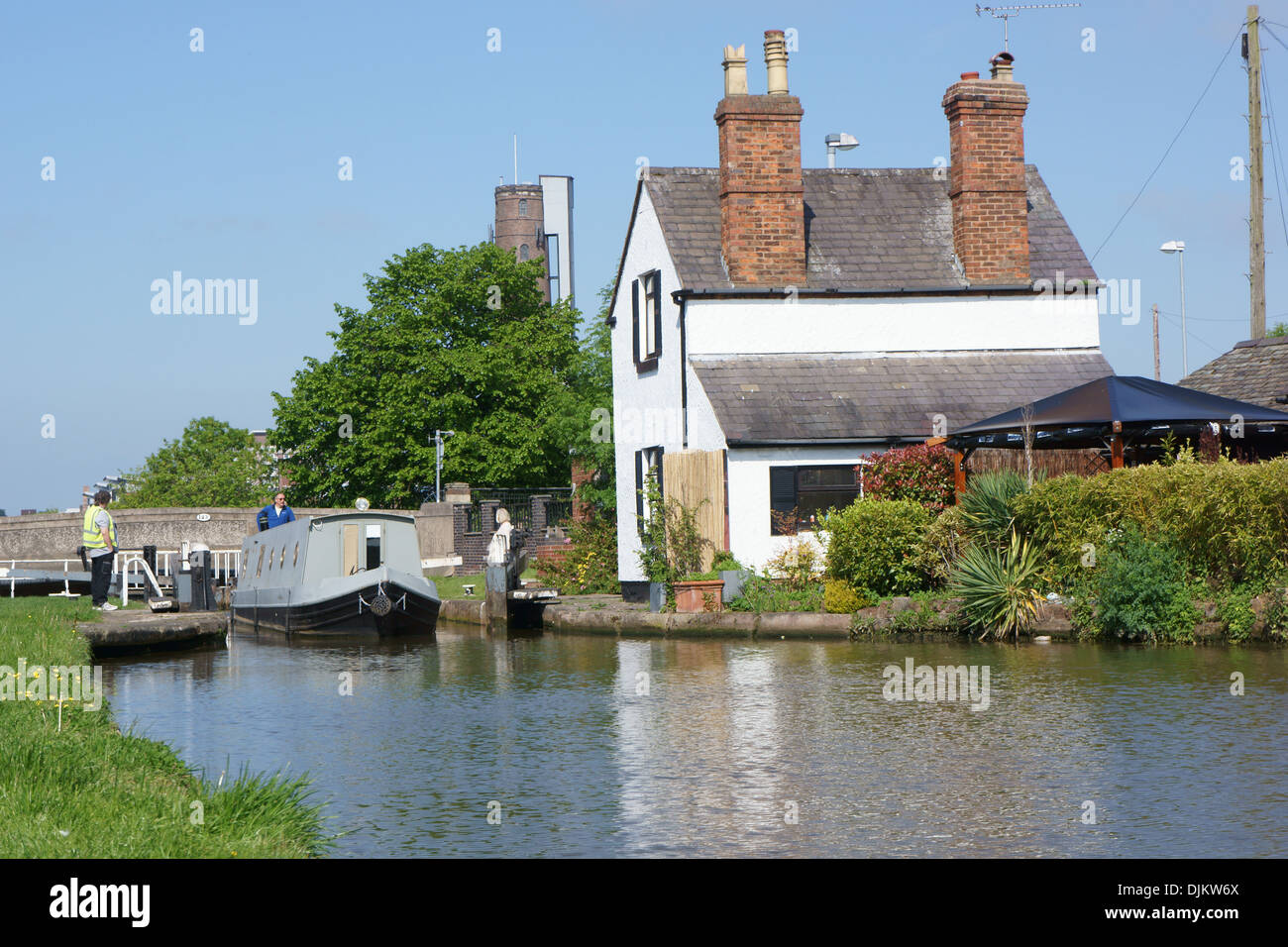 Ein Narrowboat kommt durch eine Schleuse am Chester Kanal in Cheshire, England. Stockfoto