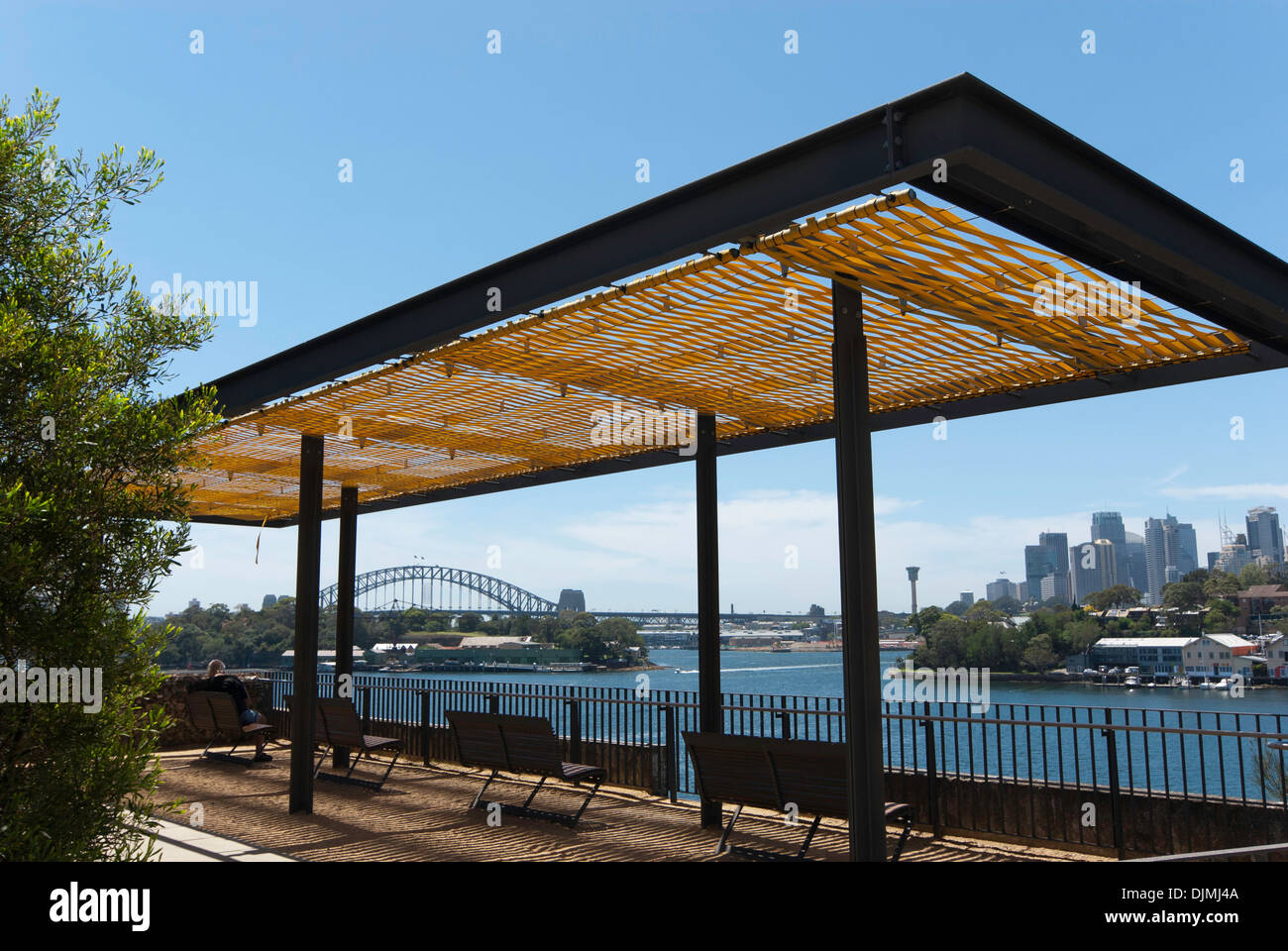 Schattige Sitzecke Ballast Point Park, Sydney, mit der Hafen, die Stadt und die Brücke im Hintergrund. Stockfoto