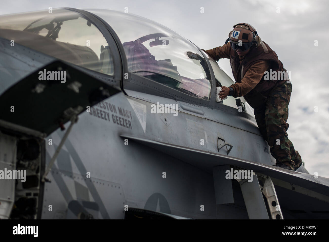 Luftfahrt Maschinist Mate Flieger Iwalani Yamaguchi, von Kaneohe, Hawaii, reinigt die Überdachung von einer F/A-18F Super Hornet von D Stockfoto