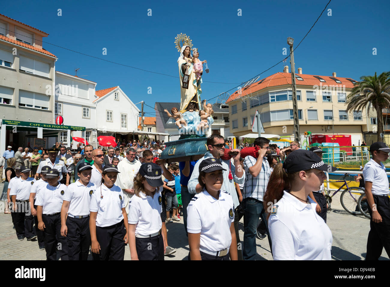 Junge Polizei Kadetten mit Statue der Jungfrau Maria in einer religiösen Prozession im Dorf Corrubedo, Galicien, Spanien Stockfoto