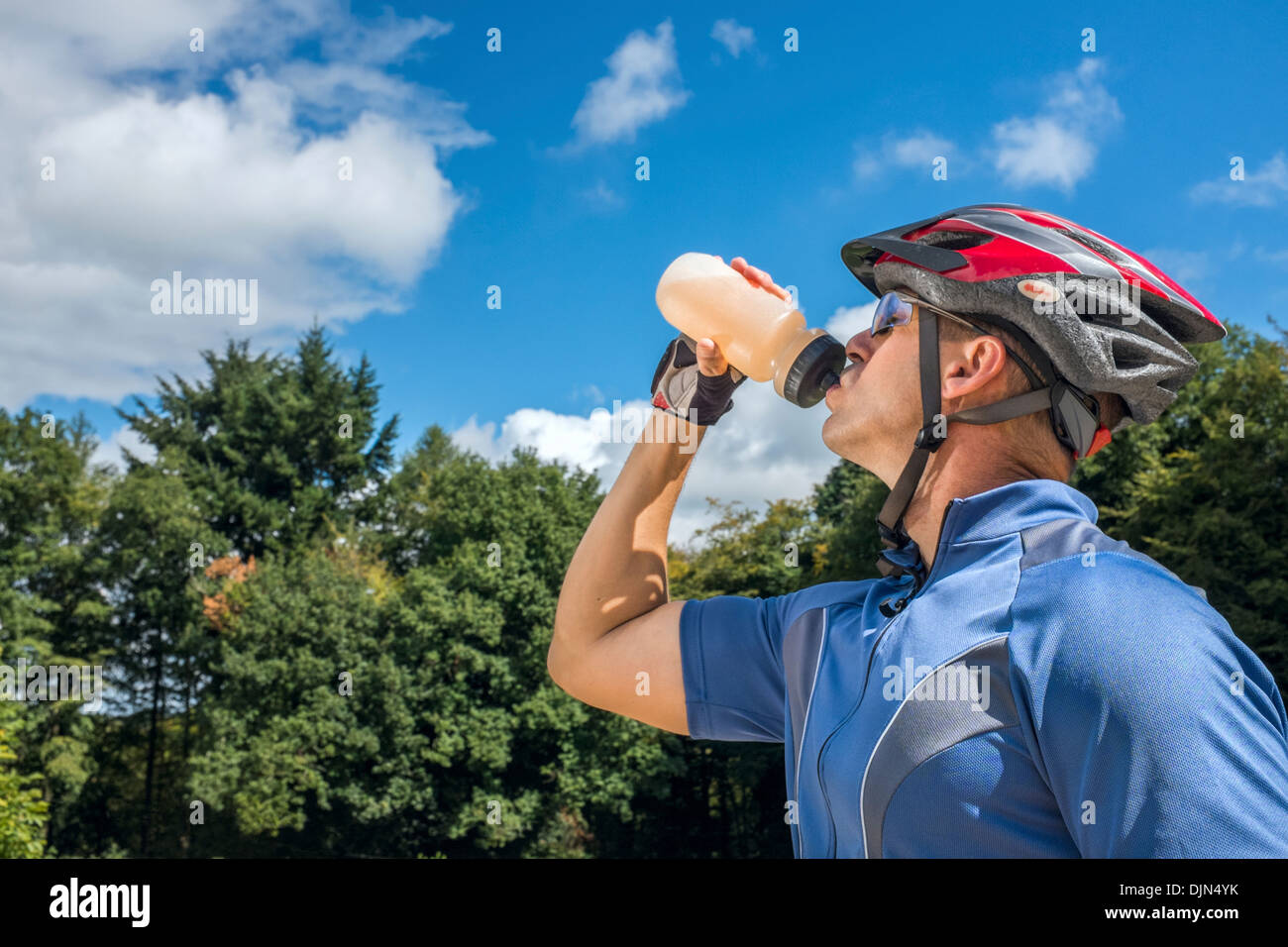 Männliche Radfahrer trinken aus einer Flasche Wasser. Stockfoto