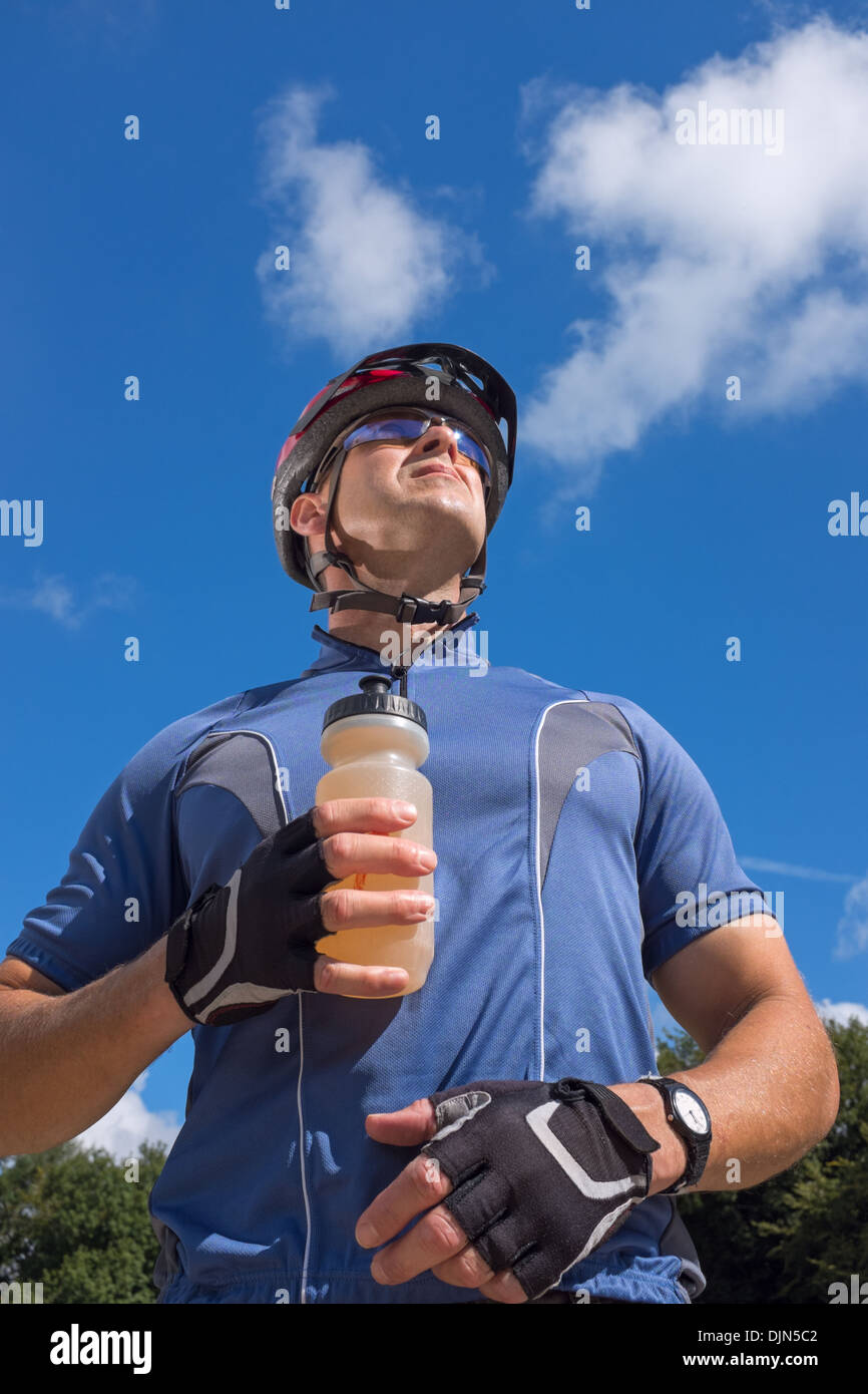 Männliche Radfahrer einen Drink in eine Flasche Wasser zu halten. Stockfoto