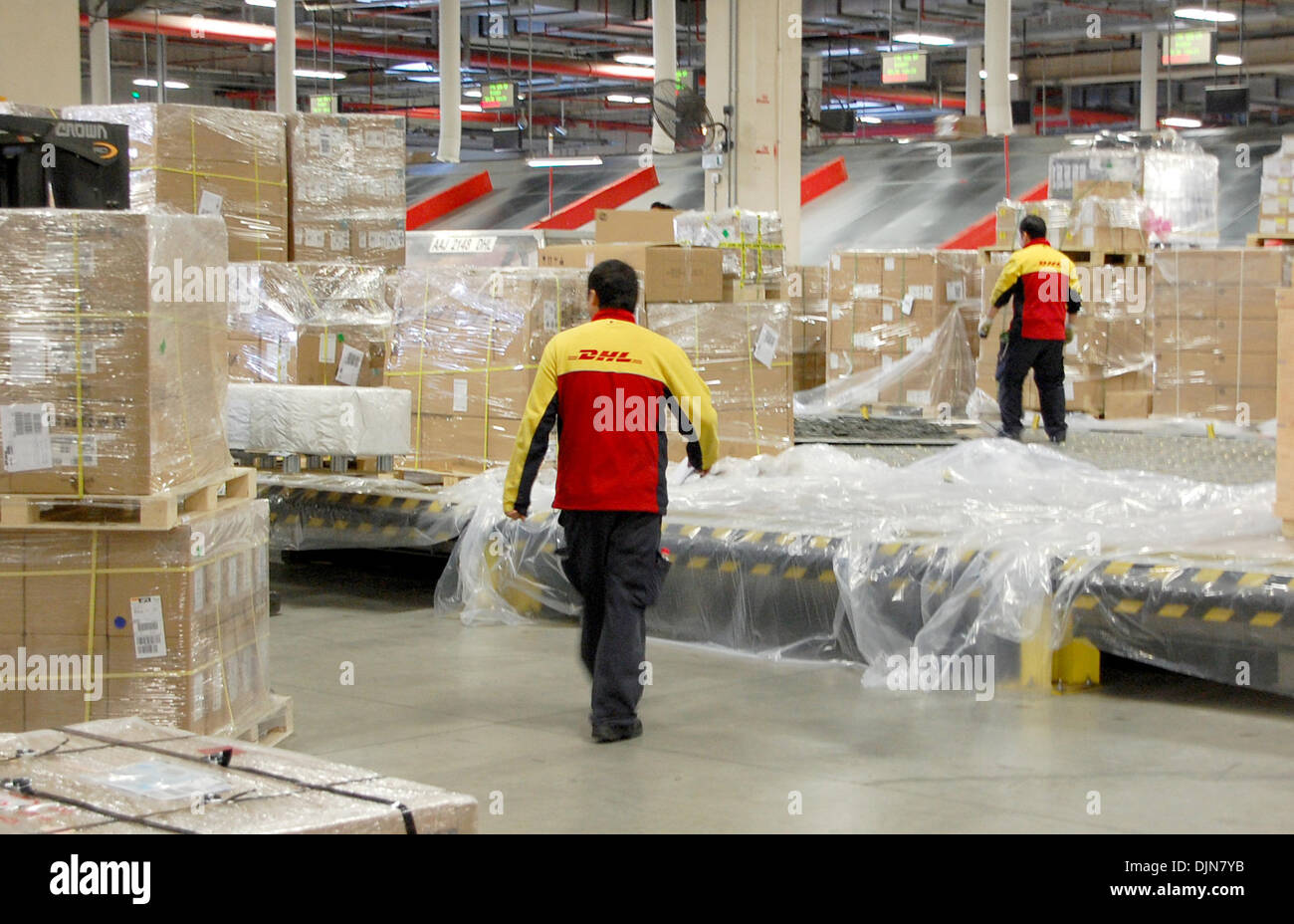 das Drehkreuz Shanghai, China. 29. November 2013. DHL-Mitarbeiter laden Parzellen am Drehkreuz Schanghai, China, 29. November 2013. Der weltweit führenden Logistikunternehmen "Deutsch Post DHL" will die größte asiatische Drehkreuz ausbauen. Die Sammelstelle wurde vor einem Jahr eröffnet. Foto: STEPHAN SCHEUER/Dpa/Alamy Live News Stockfoto