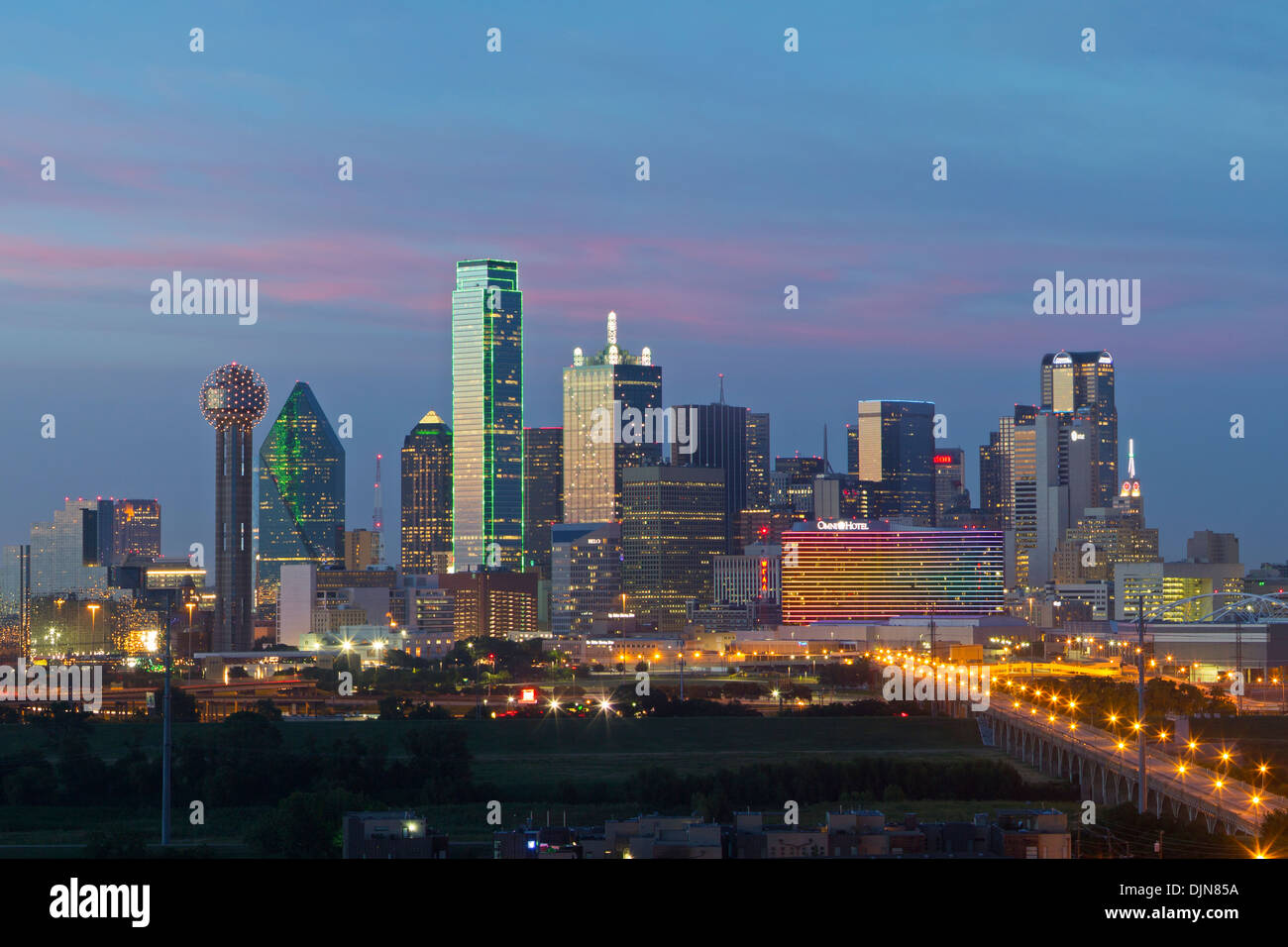Die Skyline von Dallas beginnt zu leuchten an einem lauen Sommerabend. In der Skyline ist der berühmte Reunion Tower. Stockfoto