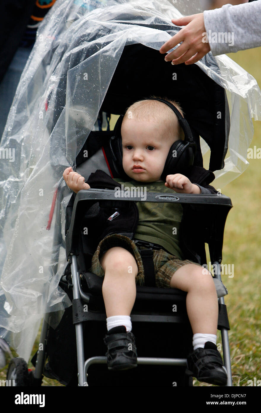 28. März 2010 - St. Petersburg, Florida, USA - DIRK SHADD |  Zeiten. SP 320561 SHAD GRANDPRIX 20 (28.03.10 St. Petersburg) mit einem Regenponcho, drapiert über seinen Kinderwagen, Reiter Gustafson (Cq), 1 1/2, schaut zu, wie seine Mutter Erika Gustafson (Cq), aus St. Petersburg, der Poncho während des Rennens Indy Lights auf der Honda Grand Prix von St. Petersburg Sonntagnachmittag hält (28.03.10). Stockfoto