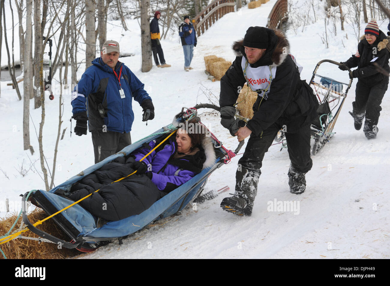 6. März 2010 läuft - Anchorage, Alaska, USA - SAM DELTOUR Belgien seinen Korb und Iditarider LINDA CHOWNS von Pennsylvania und über einen Heuballen während der Rundung einer schwierigen Ecke Universität See entlang während des Iditarod feierlichen Beginn Samstag. (Kredit-Bild: © Erik Hill/Anchorage Daily News/ZUMA Press) Stockfoto