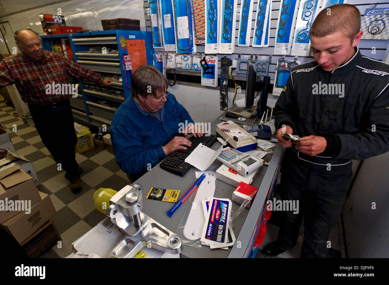 24. April 2010 - neue Ägypten, New Jersey, USA - sieht als RICHARD PATTERSON, Fahrer BRIAN PAPIEZ sein Geld zählt, nachdem Teile-Experte MARK BLACKWELL, sitzend, deckt sich die Teile sind erforderlich, um Papiezs Auto reparieren und es auf 3/8 Meile, roten Ton neuen Ägypten Speedway, die Website von short-Track-Autorennen seit den 1950er Jahren wieder auf den Weg bekommen.  In dieser Kleinstadt New Jersey die Grenzen der Stockfoto