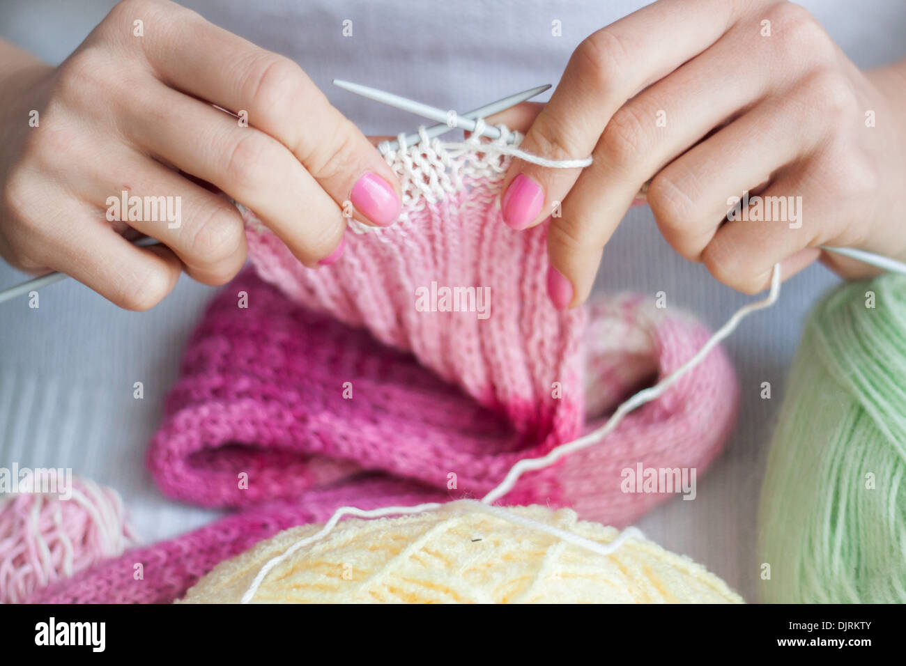 Stricken Hände "Stricknadeln" Mädchen Frau Closeup Stiche Handwerk Hobby Garn rosa Stockfoto