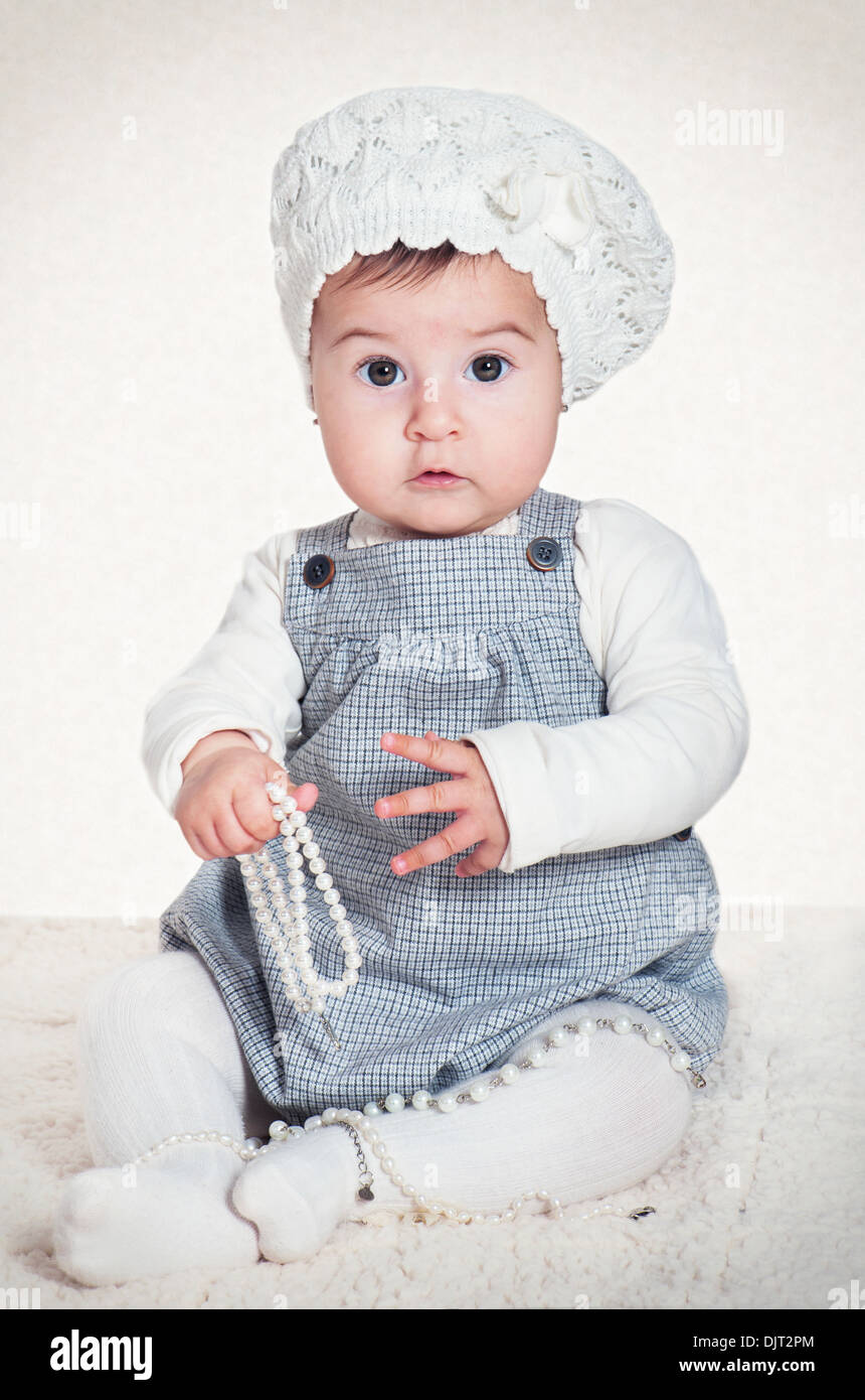 Süßes Mädchen in eine Baskenmütze mit Perlen in Händen Stockfoto