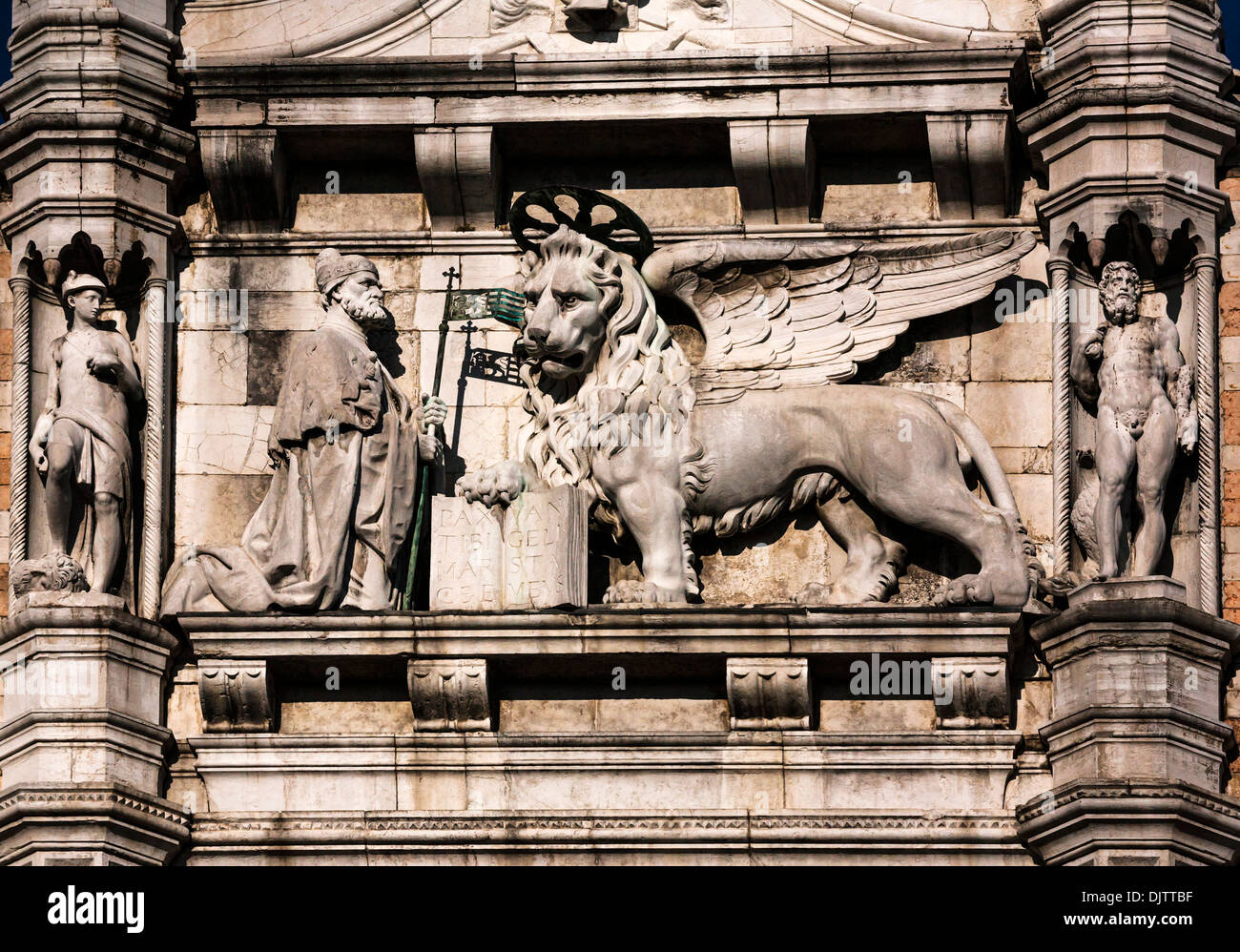 Detail-Aufnahme eines geflügelten Löwen mit ein offenes Buch und eine kniende Doge auf den Dogenpalast, Venedig, Veneto, Italien. Stockfoto