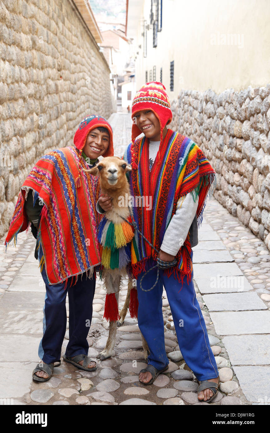 Quechua-Jungs mit einem Lama, Cuzco, Peru. Stockfoto
