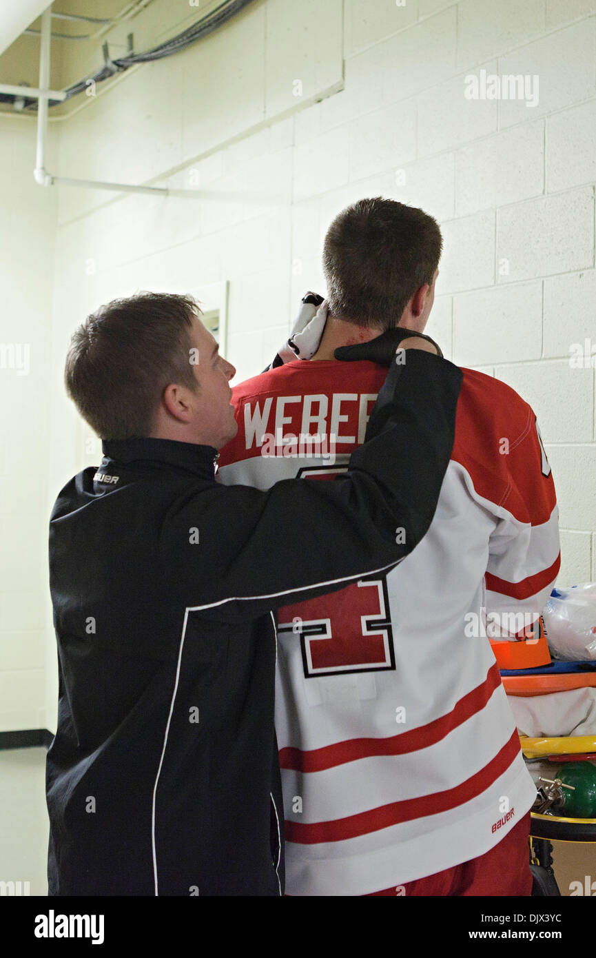 23. Oktober 2010 - Oxford, Ohio, Vereinigte Staaten von Amerika - Miami (OH) Universität links Verteidiger wird Weber (#4) von einem Sanitäter in der ersten Periode des Spiels Miami University Steve Cady Arena at Goggin Ice Center in Oxford, Ohio Samstag, 23. Oktober 2010 gearbeitet. Weber hatte eine tiefe Schnittwunde an den Hals von einem Nordmichigan Spieler Skate und wurde zum lokalen Hospit gehetzt Stockfoto