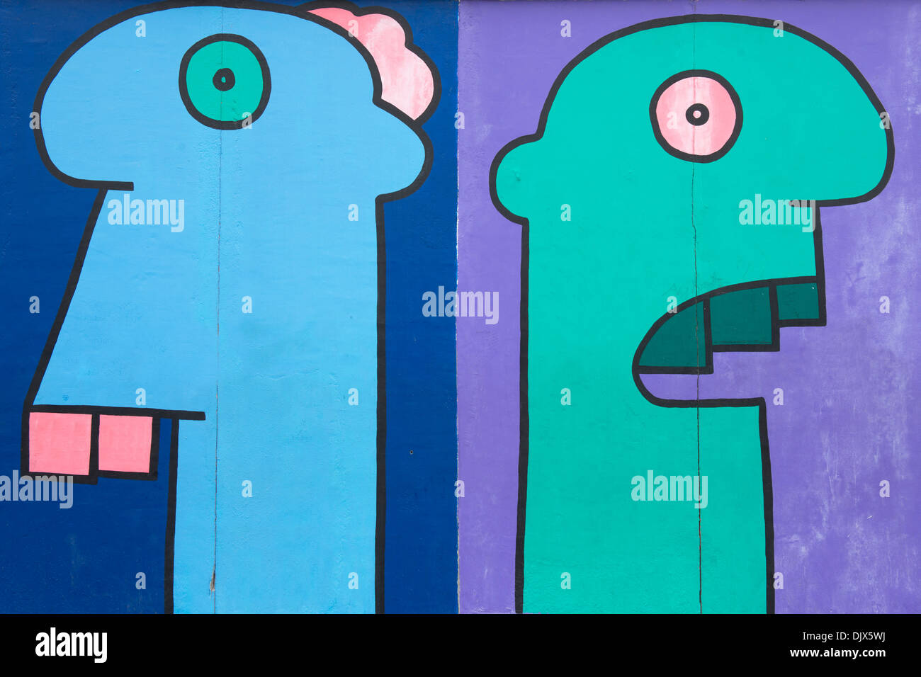 Zwei bunte Köpfe gemalt auf einem Abschnitt der East Side Gallery in Berlin, Deutschland. Stockfoto