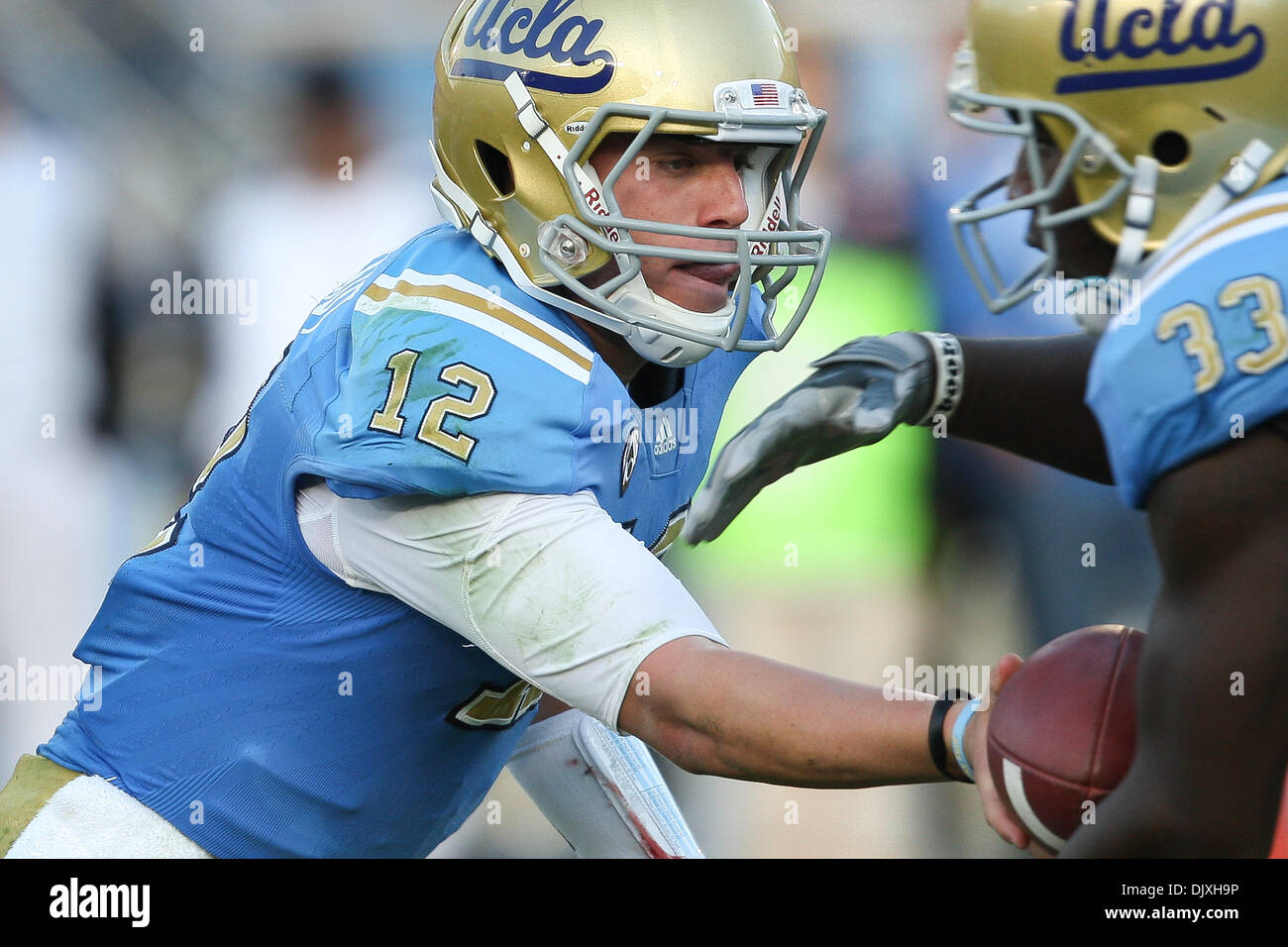 6. November 2010 übergibt - Pasadena, California, Vereinigte Staaten von Amerika - UCLA Bruins Quarterback Richard Brehaut #12 (L) den Ball von UCLA Bruins Runningback Derrick Coleman #33 (R) während der UCLA Vs Oregon State Spiel in der Rose Bowl. Die Bruins fuhr fort, um den Biber zu besiegen, schlagen einen 51-Yard Fieldgoal während am Rande der Überstunden mit 1 Sekunde verlassen, was zu einer endgültigen sc Stockfoto