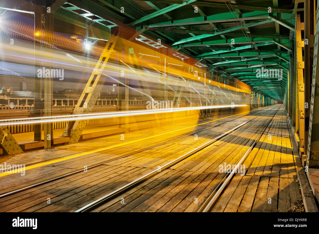 Abstrakte Straßenbahn Lichtspur im unteren Teil des Stahlbinders Gdanski Brücke in Warschau, Polen, Fluchtpunktperspektive. Stockfoto