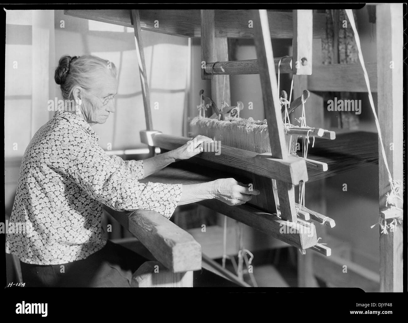 Tante Lizzie Reagan wird in der Pi Beta Phi Schule in Gatlinburg, Tennessee gezeigt, wie sie altmodisches Denim webt. Dieses Foto zeigt traditionelle Webtechniken und die Rolle der Frauen im Handwerk während des frühen 20. Jahrhunderts. Stockfoto