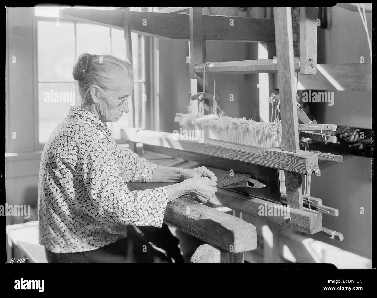 Tante Lizzie Reagan wird in der Pi Beta Phi School in Gatlinburg, Tennessee gezeigt, wie sie altmodische jean webt. Ihre Handwerkskunst im Weben traditioneller Stoffe ist eine seltene Kunst, die die Kunst der historischen Textilproduktion demonstriert. Stockfoto