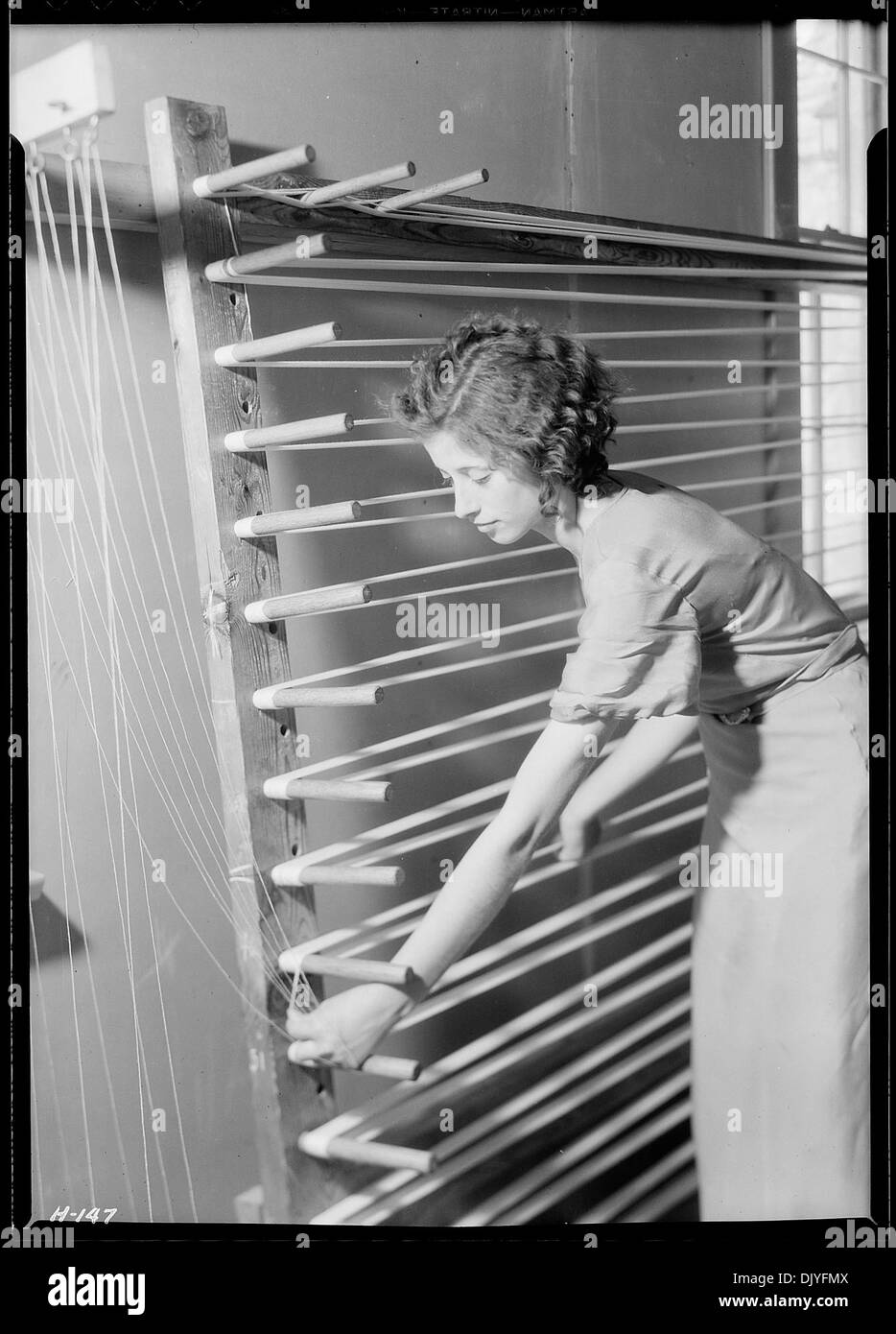 Beula Ogle bereitet die Kette für das Weben an der Pi Beta Phi School in Gatlinburg, Tennessee vor. Als neue Weberin lernt sie traditionelle Techniken an der Schule, die für die Erhaltung der Webkunst bekannt ist. Stockfoto