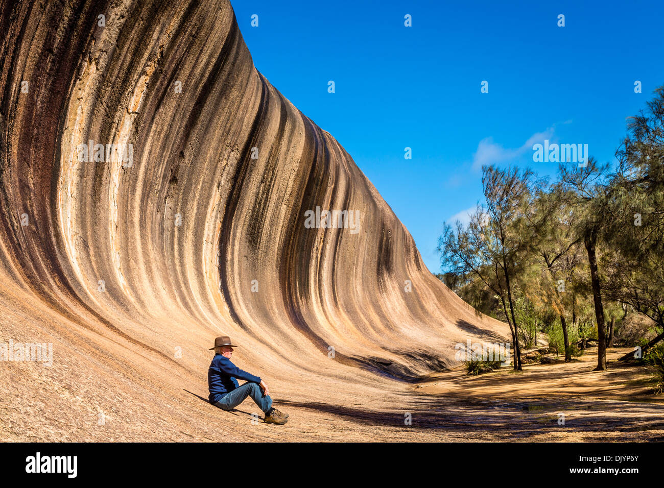 Man ruht an der Unterseite des Wave Rock, in der Nähe von Hyden, Western Australia Stockfoto
