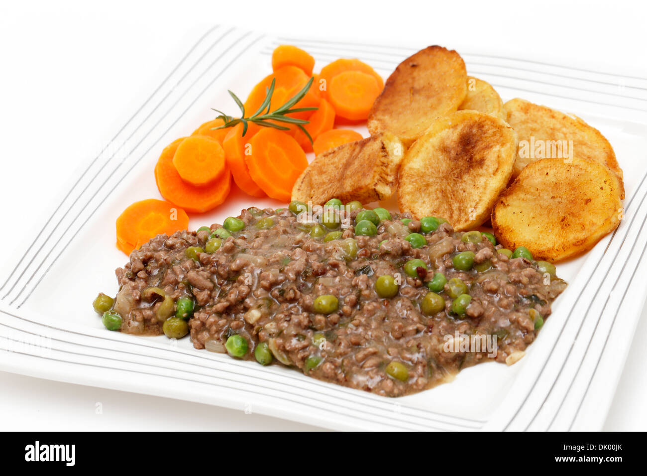 Hackfleisch mit Zwiebel, Knoblauch, Erbsen und Kräutern gekocht, serviert mit sautieren Kartoffeln und Karotten gekocht Stockfoto