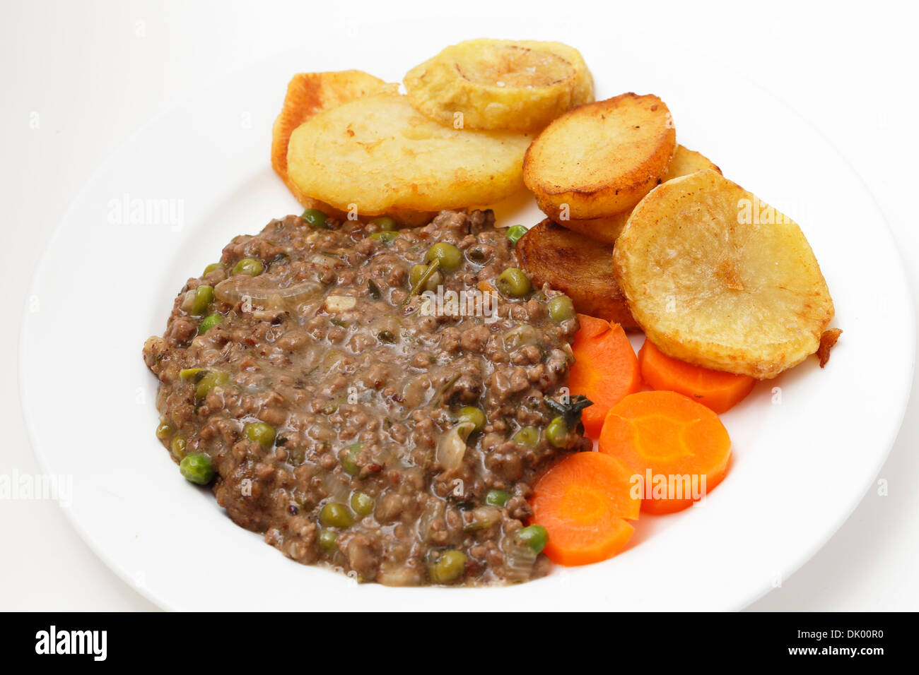 Hackfleisch mit Zwiebel, Knoblauch, Erbsen und Kräutern gekocht, serviert mit sautieren Kartoffeln und Karotten gekocht Stockfoto