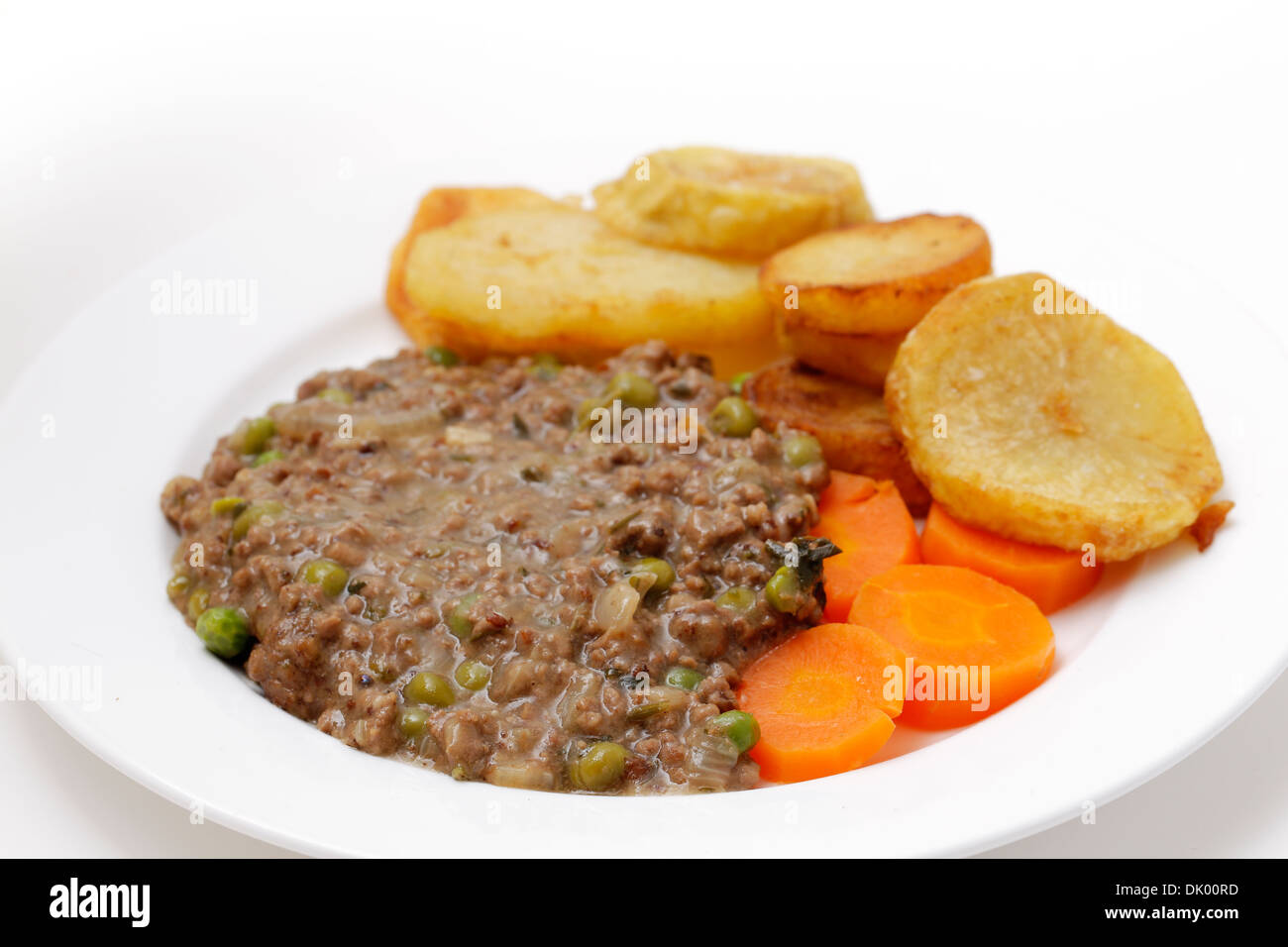 Hackfleisch mit Zwiebel, Knoblauch, Erbsen und Kräutern gekocht, serviert mit sautieren Kartoffeln und Karotten gekocht Stockfoto