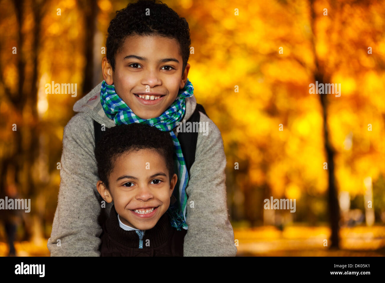 Enge Porträt zweier glücklich 8 und 10 jungen schwarzen Brüder stehen im Herbst orange park Stockfoto