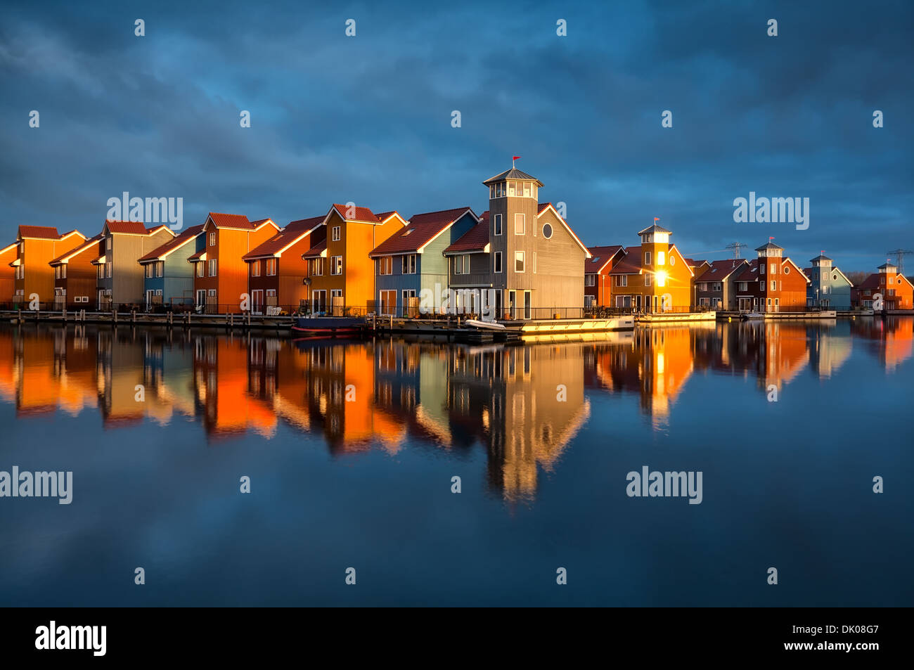 schöne bunte Gebäude auf dem Wasser im goldenen Sonnenschein, Reitdiephaven, Groningen, Niederlande Stockfoto