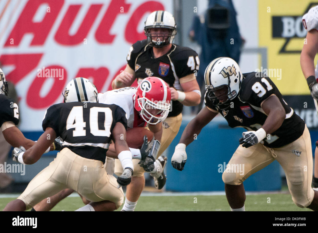 31. Dezember 2010 - Memphis, Tennessee, Vereinigte Staaten von Amerika - Georgia Bulldogs quarterback Aaron Murray (11) eilt die Mitte nur gestoppt werden, indem UCF Knights defensive Back Reggie Weams (40) und UCF Knights defensive Lineman Victor Gray (91) während der NCAA Liberty Bowl-Spiel zwischen der University of Central Florida und der University of Georgia. Endgültige Ergebnis der UCF Knights Stockfoto