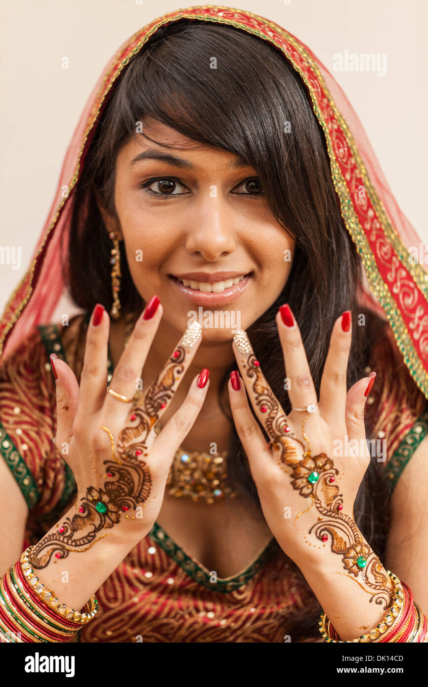 Portrait einer indischen Frau in traditionellen sāri gekleidet und sportlichen Henna Tattoos auf ihre Hände. Stockfoto