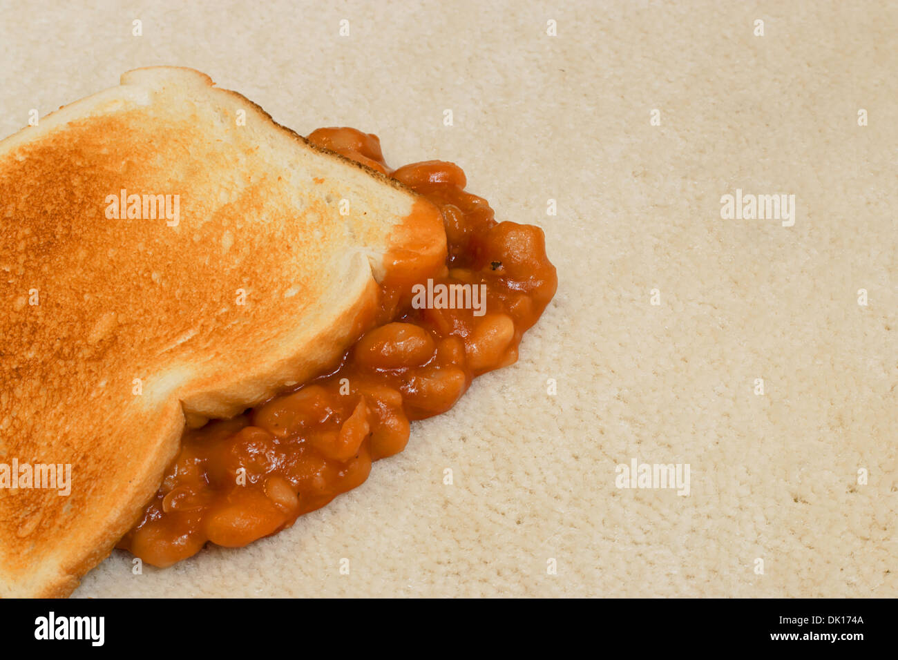 Gebackene Bohnen auf Toast versehentlich fallen gelassen und erstellen einen Teppich Fleck auf Beige Haufen Bodenbelag Stockfoto
