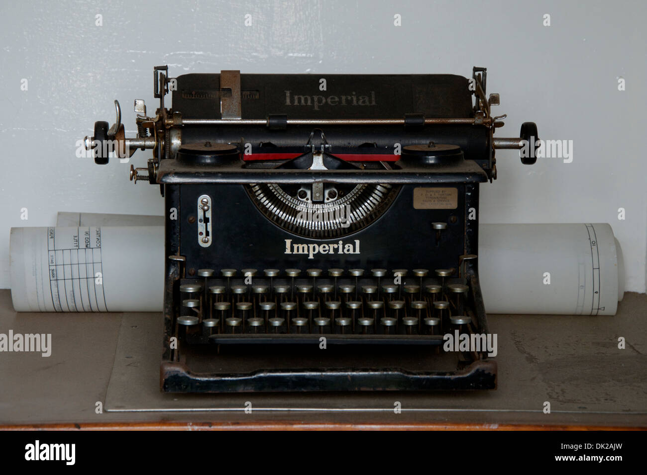 Vor dem Krieg Vintage Imperial 50 Schreibmaschine auf dem Schreibtisch mit einem architektonischen Papierrolle. Stockfoto