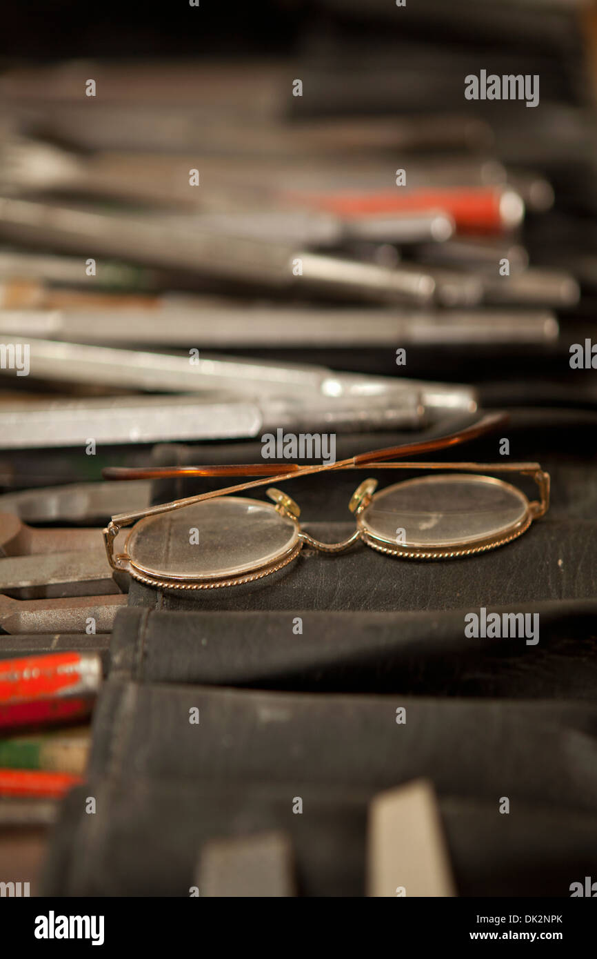 Nahaufnahme von Brillen auf des Bildhauers Tisch mit kreativ-tools Stockfoto