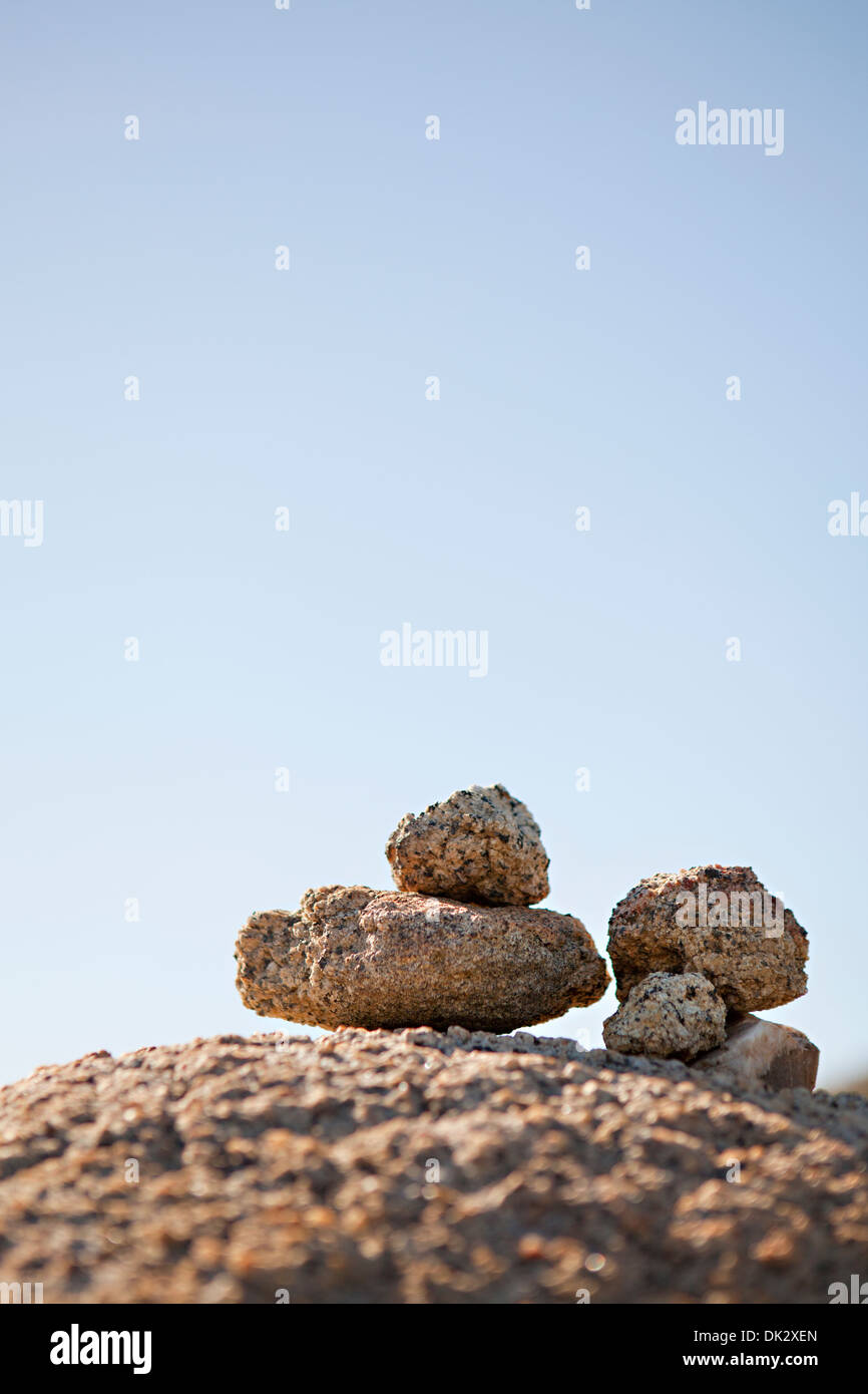 Zen-artige Steinen gegen sonnigen blauen Himmel gestapelt Stockfoto