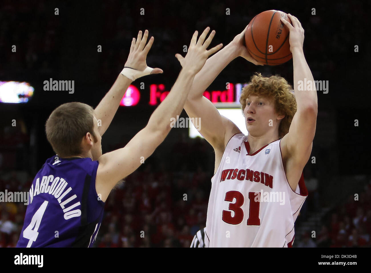 27. Februar 2011 - bewachen Madison, Wisconsin, USA - Wisconsin nach vorn Mike Bruesewitz (31) sieht um zu übergeben, während wird bewacht von Northwestern Alex Marcotullio (4) im ersten Halbjahr Aktion. Wisconsin besiegte Northwestern 78-63 im Kohl Center in Madison, Wisconsin. (Kredit-Bild: © John Fisher/Southcreek Global/ZUMAPRESS.com) Stockfoto