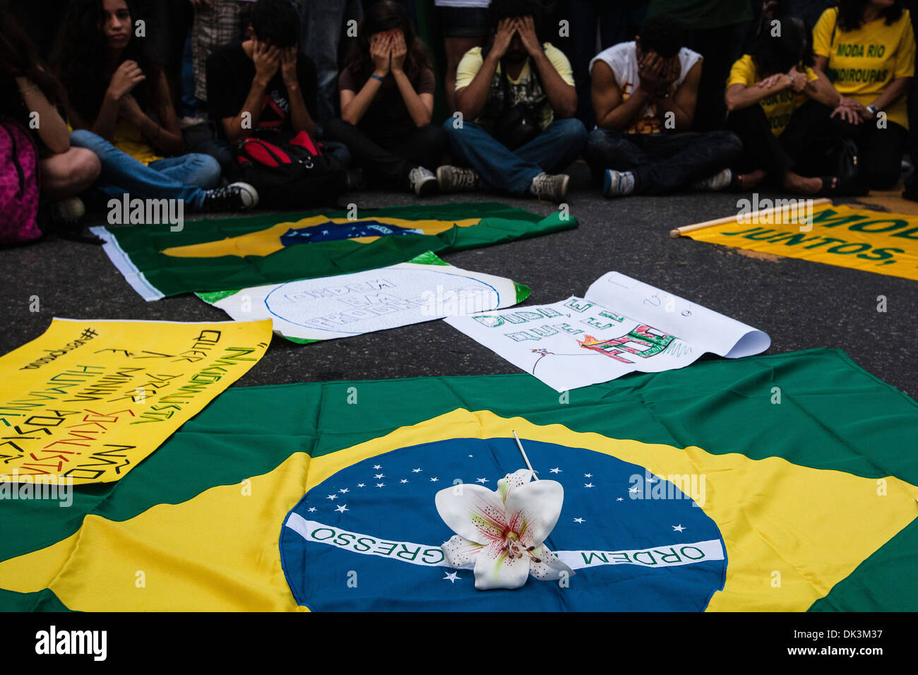 Brasilien-2013 protestiert, dass junge Menschen ihre Gesichter in Schande für Korruption in der brasilianischen Regierung, Brasilien Flagge und Blume abdecken Stockfoto