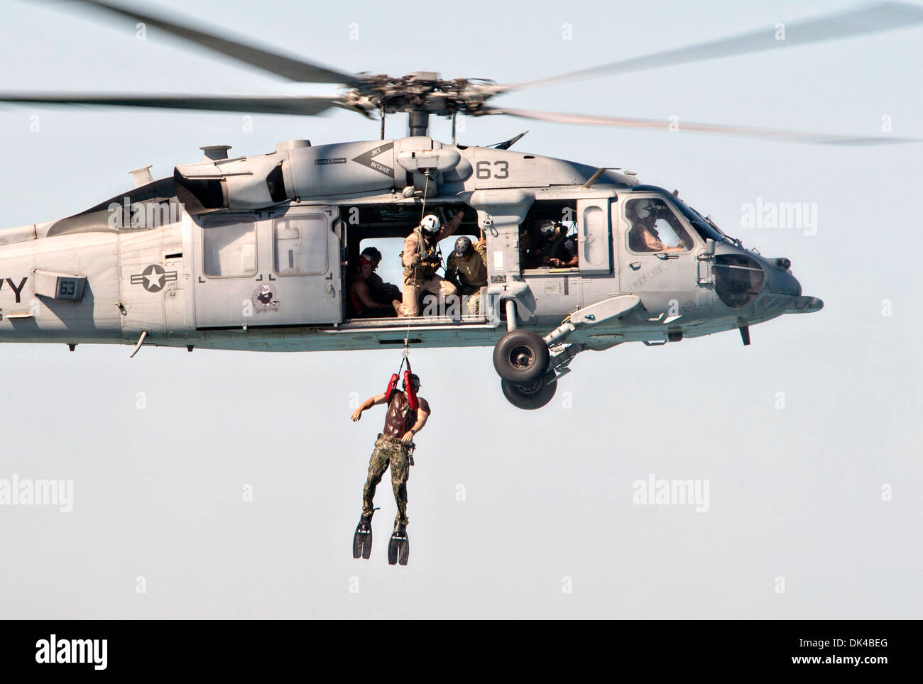 US Navy Matrosen zugewiesen Commander Task Group 56,1 und Matrosen der Royal bahrainische Seestreitkräfte eine Mine Pausgerät Operation aus einem MH-60 s Seahawk Hubschrauber während des Trainings Neon Antwort 24. Oktober 2013 in das Arabische Meer durchführen. Neon-Reaktion ist eine bilaterale, explosive Ordnance Entsorgung und Tauchen Engagement zwischen der US-Marine und Königreich von Bahrain Defense Forces. Stockfoto