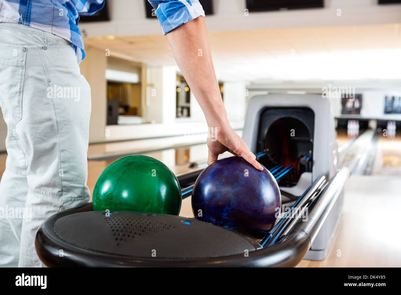 Menschenhand Abholung Bowling-Kugel von Rack Stockfoto