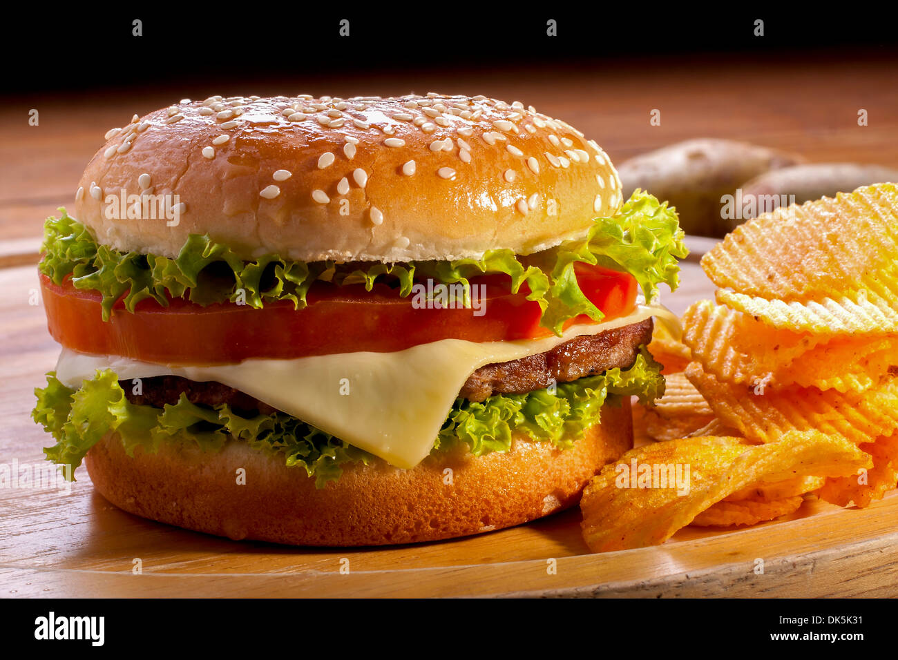 Burger mit Pommes Frites auf Holzplatten und schwarzen Hintergrund. Stockfoto