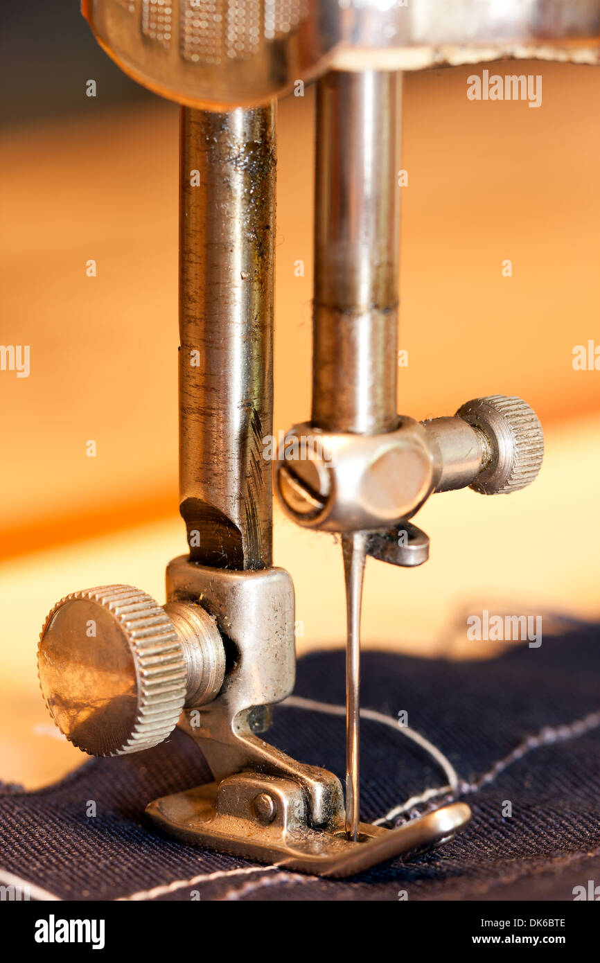 Nahaufnahme einer Nadel einer Nähmaschine, die einem Textil oder Tuch oder Stoff nähen ist Stockfoto