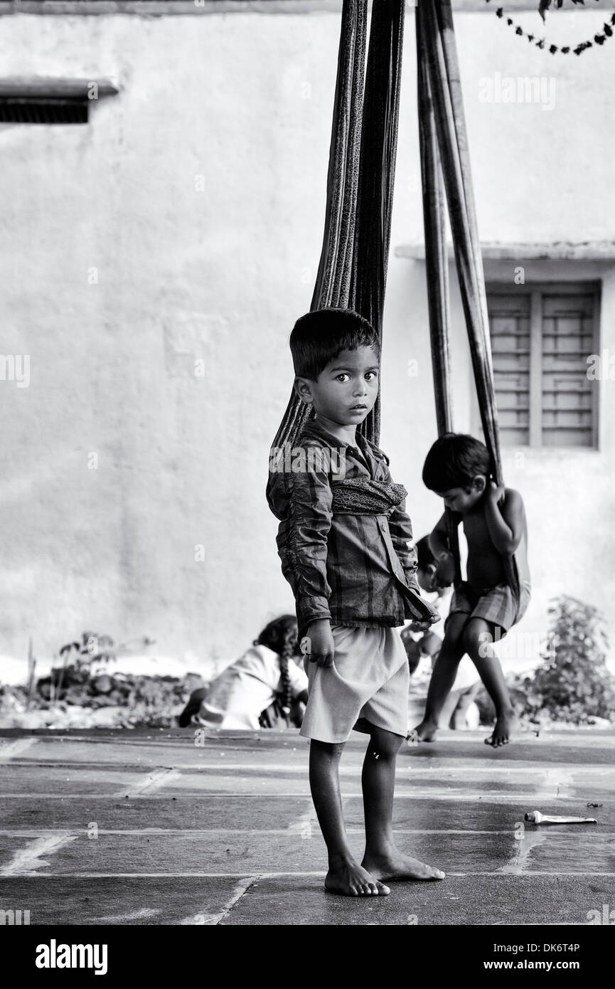 Indischen Jungen spielen auf Sari Schaukeln zu Hause in einem indischen Dorf. Andhra Pradesh, Indien. Schwarz und weiß. Stockfoto