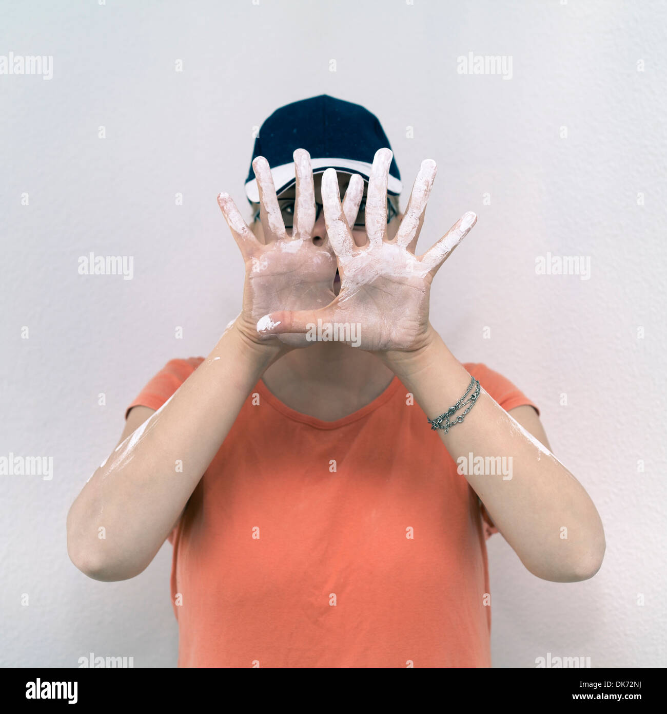 Kreative Frau zeigt ihre befleckten Hände mit weißer Farbe. Stockfoto