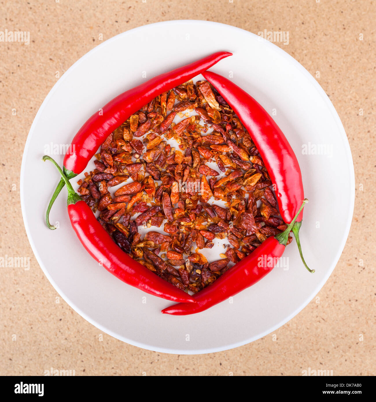 Frische und getrocknete rote scharfe Chilischoten auf Teller, in hellem Holz Hintergrund. Stockfoto