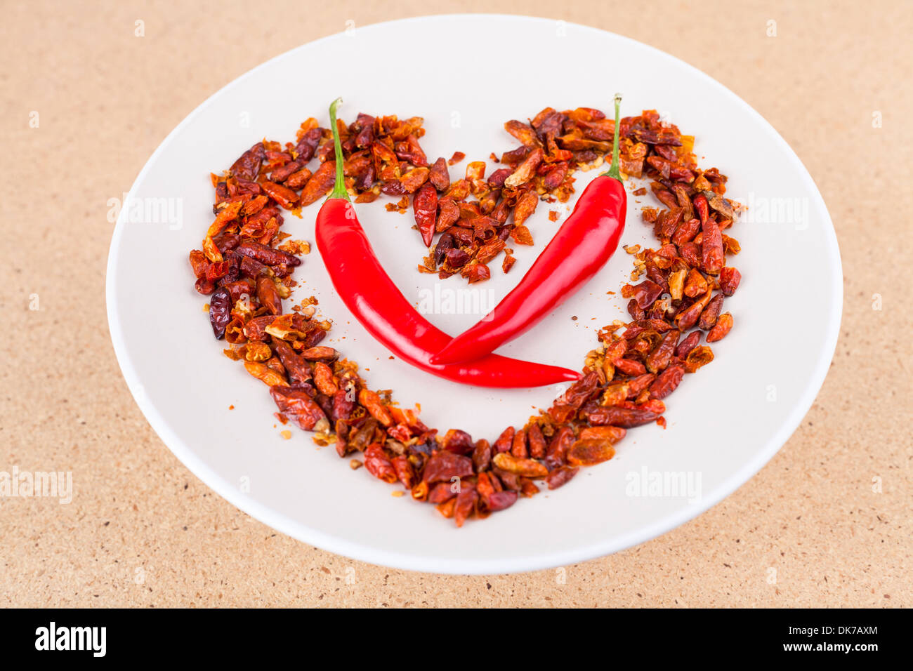 Heiße Liebe Konzept, rote Chilischoten auf Teller in Herzform angeordnet. Stockfoto