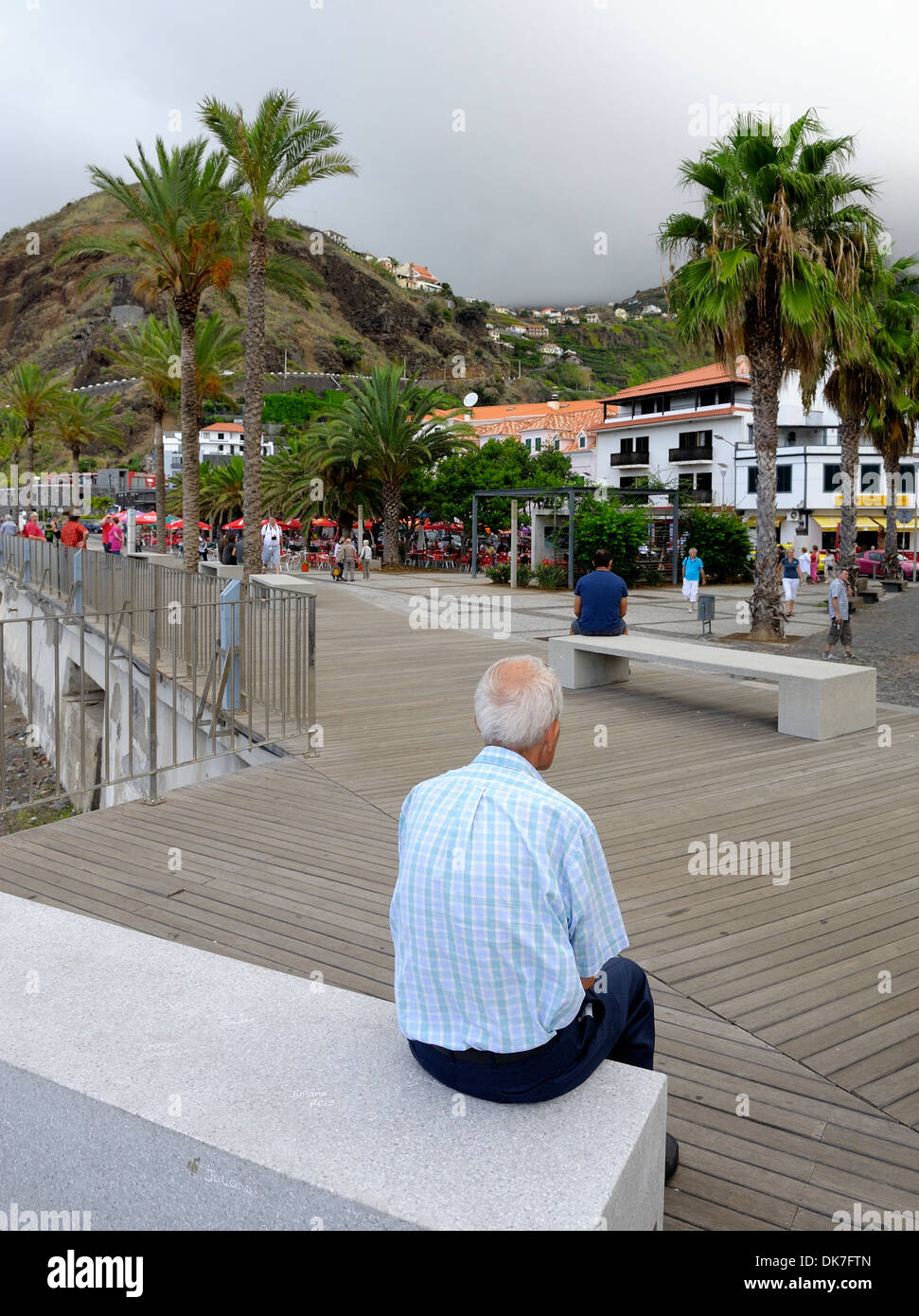 Ribeira Brava Madeira Portugal. Ein älterer Mann sitzt auf einer konkreten Bank am Meer Stockfoto