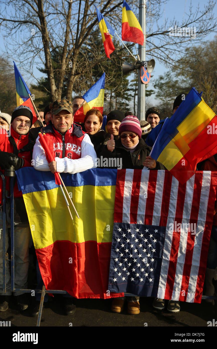 Eine rumänische Familie beobachten die National Day Parade in Bukarest, Rumänien 1. Dezember 2013, drapiert eine amerikanische Flagge neben ihrer nationalen Farben zur Unterstützung der Marinekorps-Einheit an der Veranstaltung marching. Space-Marines und Segler aus Schwarzmeer Rotations Kraft 14 Stockfoto