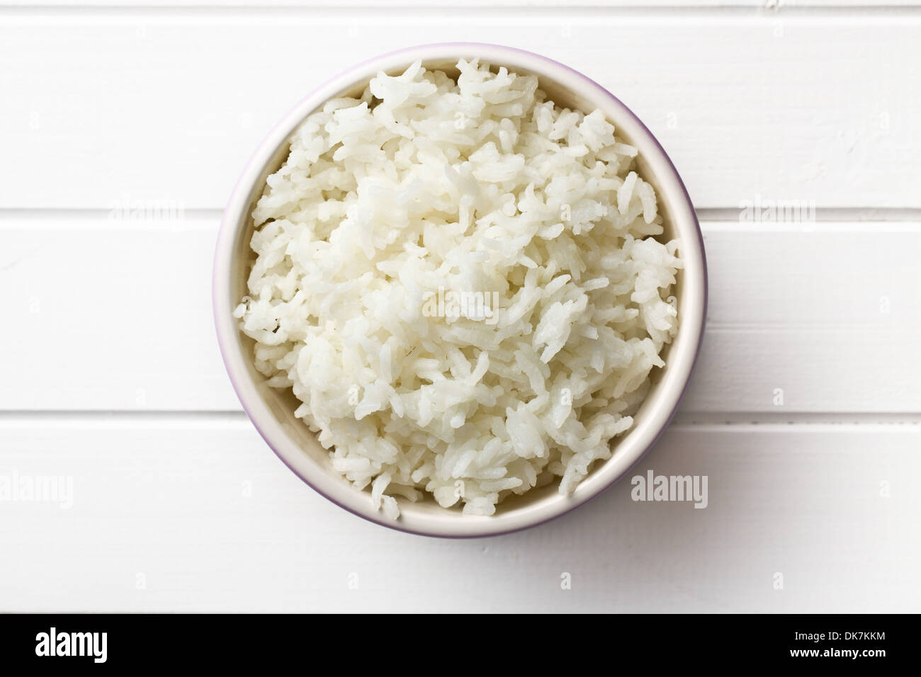 Draufsicht der Jasmin-Reis in Keramikschale auf weißer Holztisch Stockfoto