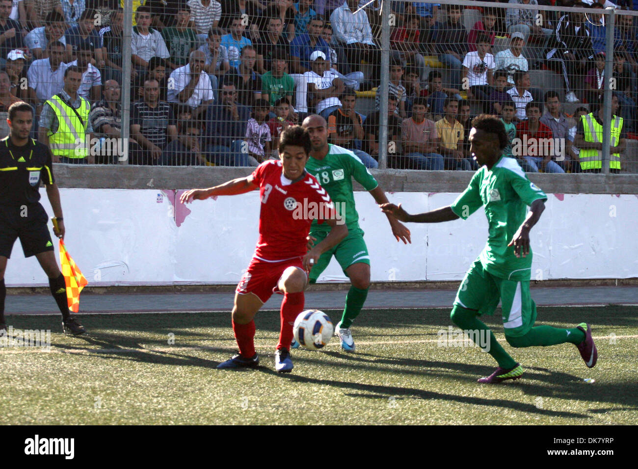 3. Juli 2011 - Ramallah, Westjordanland - palästinensischen Spieler und Afghanistan Spieler Herausforderung für den Ball während einer Fußball-match zwischen Palästina und Afghanistan Nationalmannschaften in der West Bank Stadt Ramallah, Sonntag. Die palästinensischen Fußballnationalmannschaft zog 1-1 gegen Afghanistan am Sonntag, ein Ergebnis, das die Palästinenser auf die nächste Qualifikationsrunde für die WM Vorschüsse Stockfoto