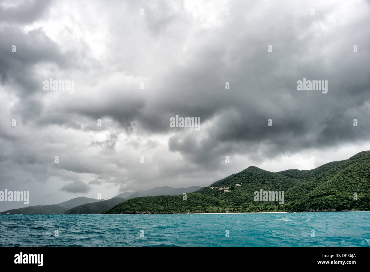 ST. JOHN, US-Jungferninseln – Sturmwolken bilden sich über der Trunk Bay auf St. John auf den US-Jungferninseln. Trunk Bay ist einer der berühmtesten Strände im Virgin Islands National Park, bekannt für seinen unberührten weißen Sand und das klare türkisfarbene Wasser. Der dramatische Himmel verleiht dem tropischen Paradies eine Atmosphäre. Stockfoto