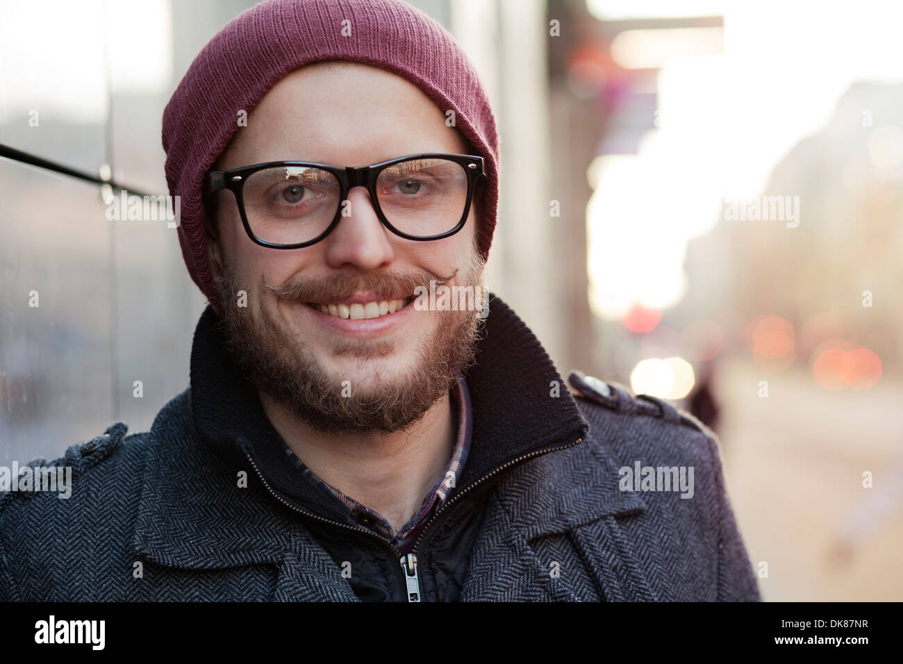 Junge lächelnde Hipster mit Schnurrbart, Bart und Brille Stockfoto